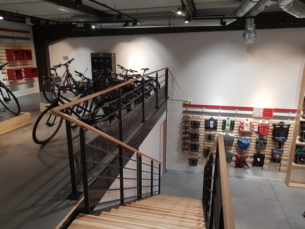 Vue de la mezzanine et de l'escalier en bois du magasin de vélos